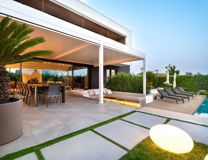 Aluminijasta pergola z bioklimatskimi lamelami na moderni terasi